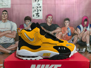 Side view of yellow and black Nike sneakers with a forefoot strap and visible heel cushioning