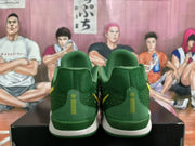 Rear view of the green Nike sneakers showing the padded collars, heel panels, and yellow vertical accents.