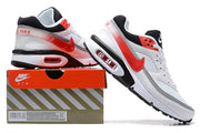 White and red Nike Air Max sneakers shown on a branded shoe box