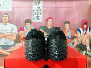 Rear view of black Nike sneakers showing textured heels and outsoles.