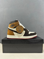 Side view of one high-top sneaker displaying the brown, black and white color blocking and burgundy outsole.
