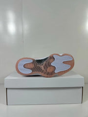 Underside view showing the translucent pink outsole and contrasting traction inserts.