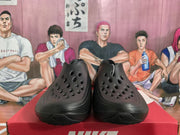 Front view of black clogs with perforated toes.