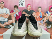 Front view of silver Nike basketball shoes with black details and small green accents.