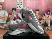 Angled view of the gray and pink Nike sneaker pair showing the side Swoosh, laces, collars, and soles.