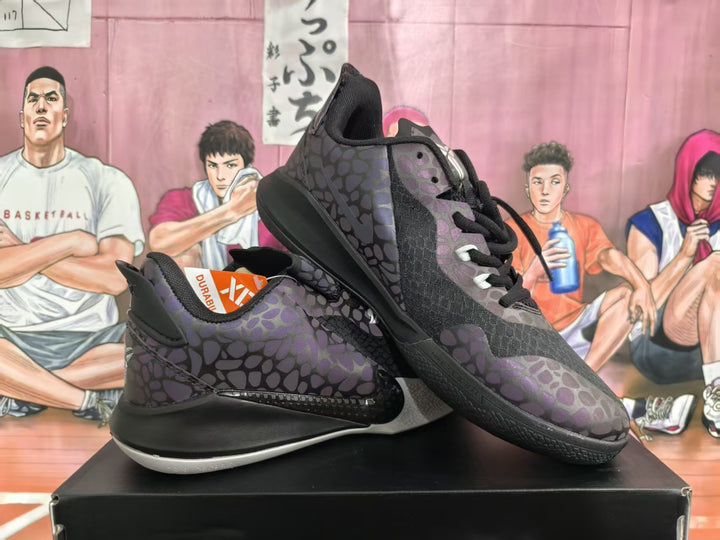 Pair of black and dark purple patterned basketball sneakers displayed on a shoebox.
