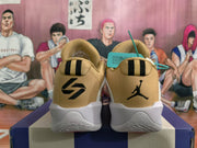 Rear view of white and tan Jordan basketball shoes with black heel logos and gold-toned details.