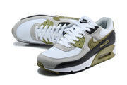 Angled view of Nike Air Max 90 QS sneakers highlighting the laces and contrasting upper panels.