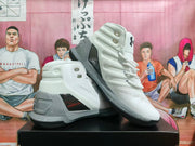 Pair of white and grey high-top basketball sneakers showing the side panels, laces, heel structure and dark outsole.