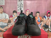 Front view of black Nike sneakers with lace-up closures, padded tongues, and purple-and-green tongue details.