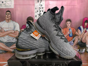 Angled view of gray high-top basketball sneakers showing the textured upper, black laces, gold accents, and XDR-branded tag.
