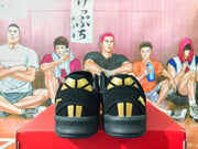 Rear view of black sneakers with gold heel accents