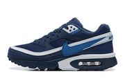 Side view of a navy blue Nike sneaker with bright blue branding, white trim and a visible heel air unit.