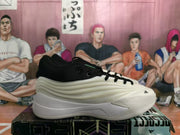 Side profile of a white and black Adidas basketball sneaker with black collar, laces, and a sculpted sole.