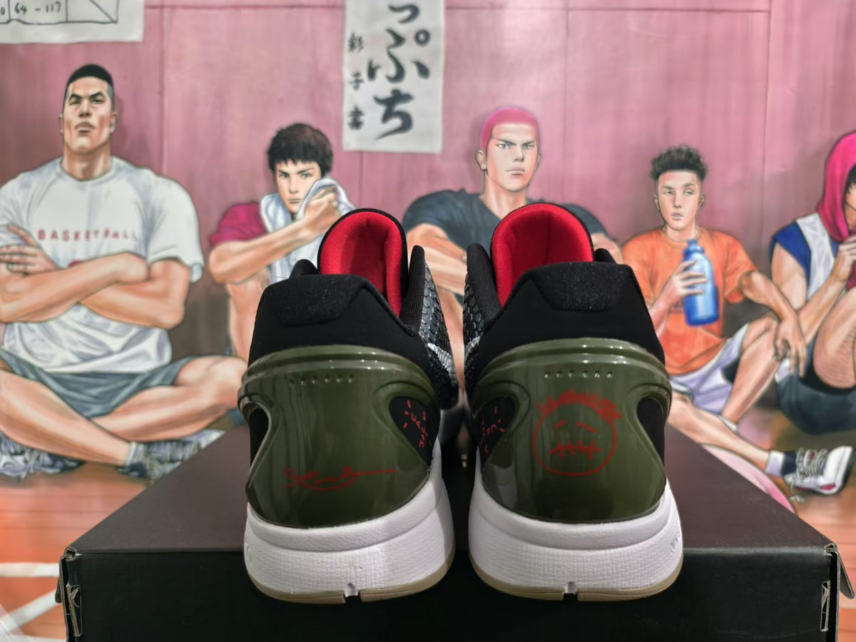 Rear view of black and white basketball shoes with red heel graphics, dark olive-toned heel panels, and white midsoles.