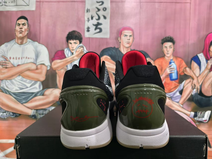 Rear view of black and white basketball shoes with red heel graphics, dark olive-toned heel panels, and white midsoles.