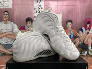 Angled view of the white high-top sneakers displaying the molded side panels, laces, pull tabs and translucent-looking outsoles.
