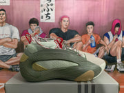 Side view of a green sneaker with layered textured panels, cream mesh detailing, and tan outsole accents.