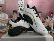 Angled lifestyle view showing both sneakers, their contrasting panels, gold-colored detailing, and patterned laces.