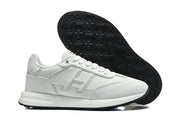 Side and outsole views of a white sneaker with black tread.