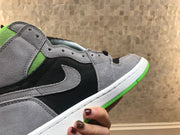 Side close-up showing grey layered panels, black side panel, grey Swoosh and green outsole edge.