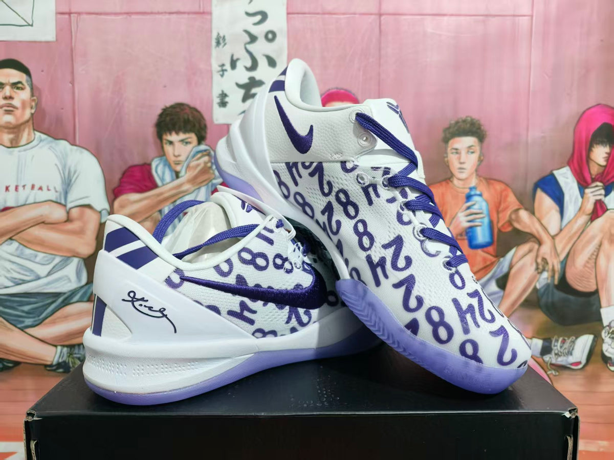 Pair of white and purple Nike basketball sneakers with graffiti-style lettering displayed on a black shoebox.