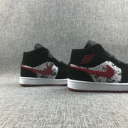Pair of black and red mid-top sneakers shown from the side.