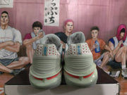 Rear view of the gray Nike basketball sneakers showing Nike heel branding, layered heel panels, and red accents.