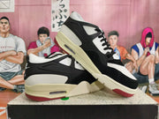 Angled view of a pair of black and white Nike sneakers with cream-toned midsoles and red outsole accents.