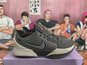 Side view of a gray and black Nike basketball sneaker showing layered side panels, the Nike Swoosh, laces, and contrasting midsole sections.