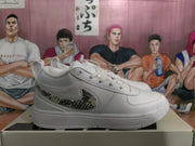 Side profile of a white Nike sneaker showing the patterned Swoosh and low-top construction.