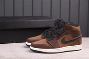 Pair of brown and black mid-top sneakers shown at an angle with white midsoles and black outsoles.