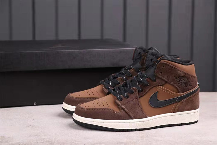 Pair of brown and black mid-top sneakers shown at an angle with white midsoles and black outsoles.