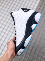Outer side view showing the white perforated upper, black midsole area, and blue outsole trim.