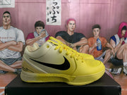 Side view showing the yellow toe, perforated upper, black Nike swoosh, and speckled midsole.