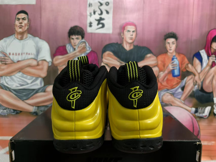 Rear view of yellow and black high-top sneakers showing green heel details and textured black outsoles.