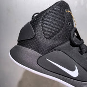 Close-up side view of the black textured upper, ankle panel, white Swoosh, and gold-tone collar tag.