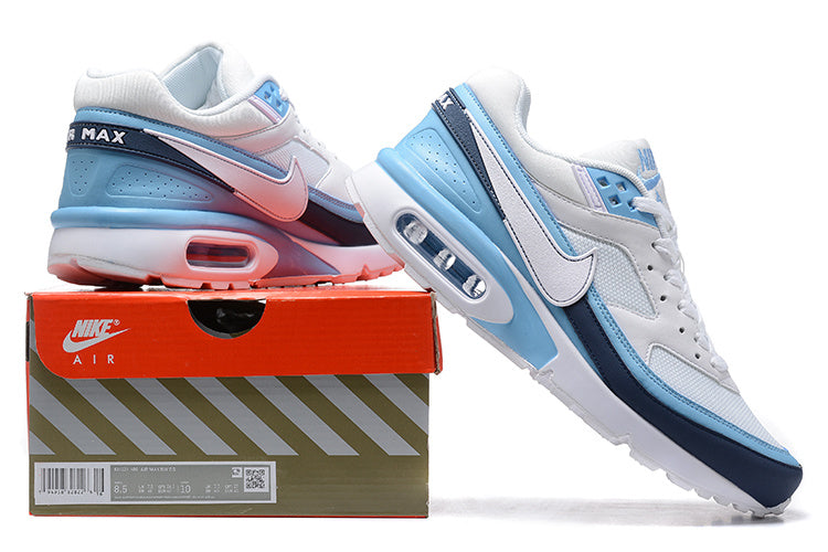 Nike Air Max sneakers in white, light blue and navy displayed beside a Nike Air box.