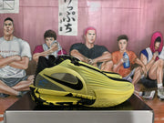 Side profile of a yellow and black Nike basketball sneaker with black Swoosh branding and a textured outsole.