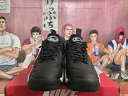 Front view of black lace-up sneakers with mesh panels and white sole accents.
