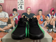 Front view of black lace-up sneakers with green side panels