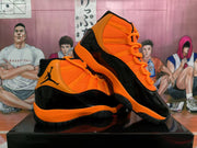 Angled view of the black and orange high-top sneakers showing both side panels, laces, and outsole details.