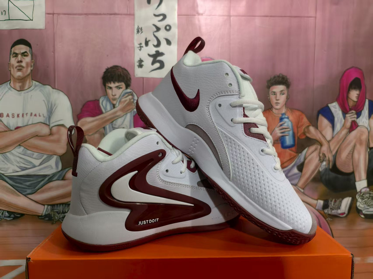 Pair of white and burgundy Nike Zoom basketball sneakers displayed on an orange box.