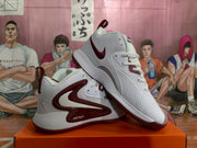 Pair of white and burgundy Nike Zoom basketball sneakers displayed on an orange box.