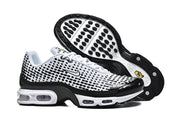 White and black Nike sneakers shown with the patterned outsole.