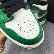 Close-up of the perforated white toe panel, green trim, and black laces.