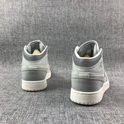 Rear view of a pair of light bone and grey high-top sneakers showing the heel panels and rubber outsoles.