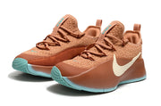 Pair of brown sneakers with cream and turquoise details in a front three-quarter view.