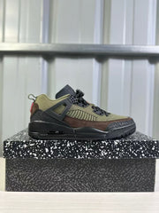 Side profile of the green and black low-top sneaker with brown overlays and patterned black outsole.