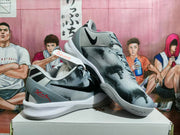 Angled view showing the patterned upper, black Swoosh, grey outsole, and red heel detail.